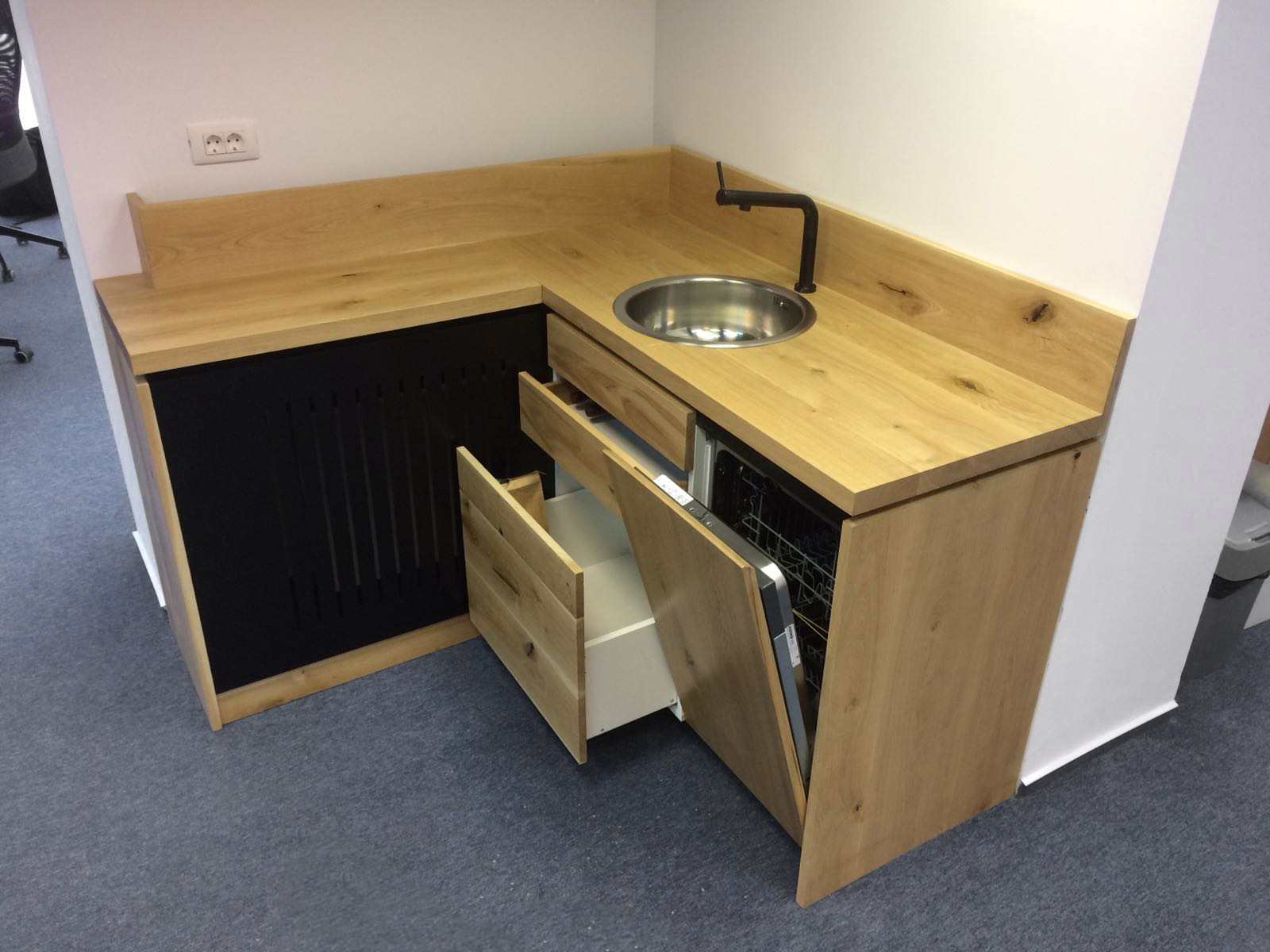 Chicinetă de colț cu sertarele și ușile deschise, mașină de spălat vase incorporată