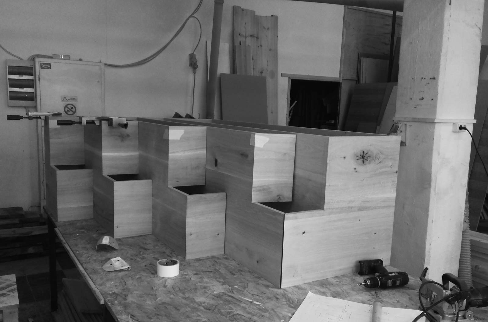 Execuție pe bancul de lucru din atelier a unui corp de mobilier din stejar în trepte cu îmbinări ale muchiilor înainte de lipire