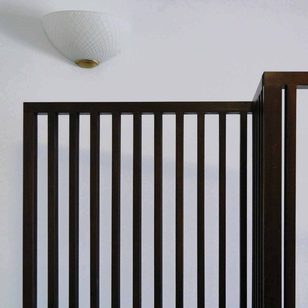 Detaliu cu îmbinările de la partea de sus a peretelui despărțitor și o lampă de perete în fundal