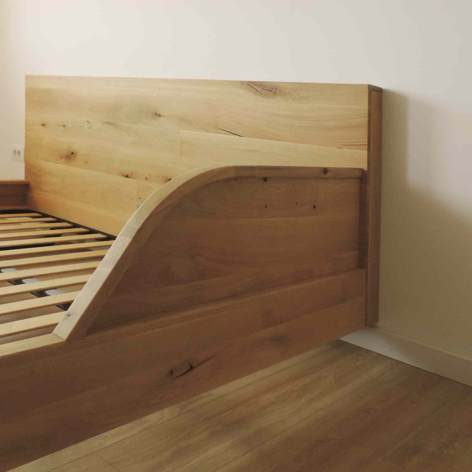 Detaliu cu tablia cu profil curbat de la capatul patului. Lemnul de stejar este la culoarea naturala, cu noduri vizibile