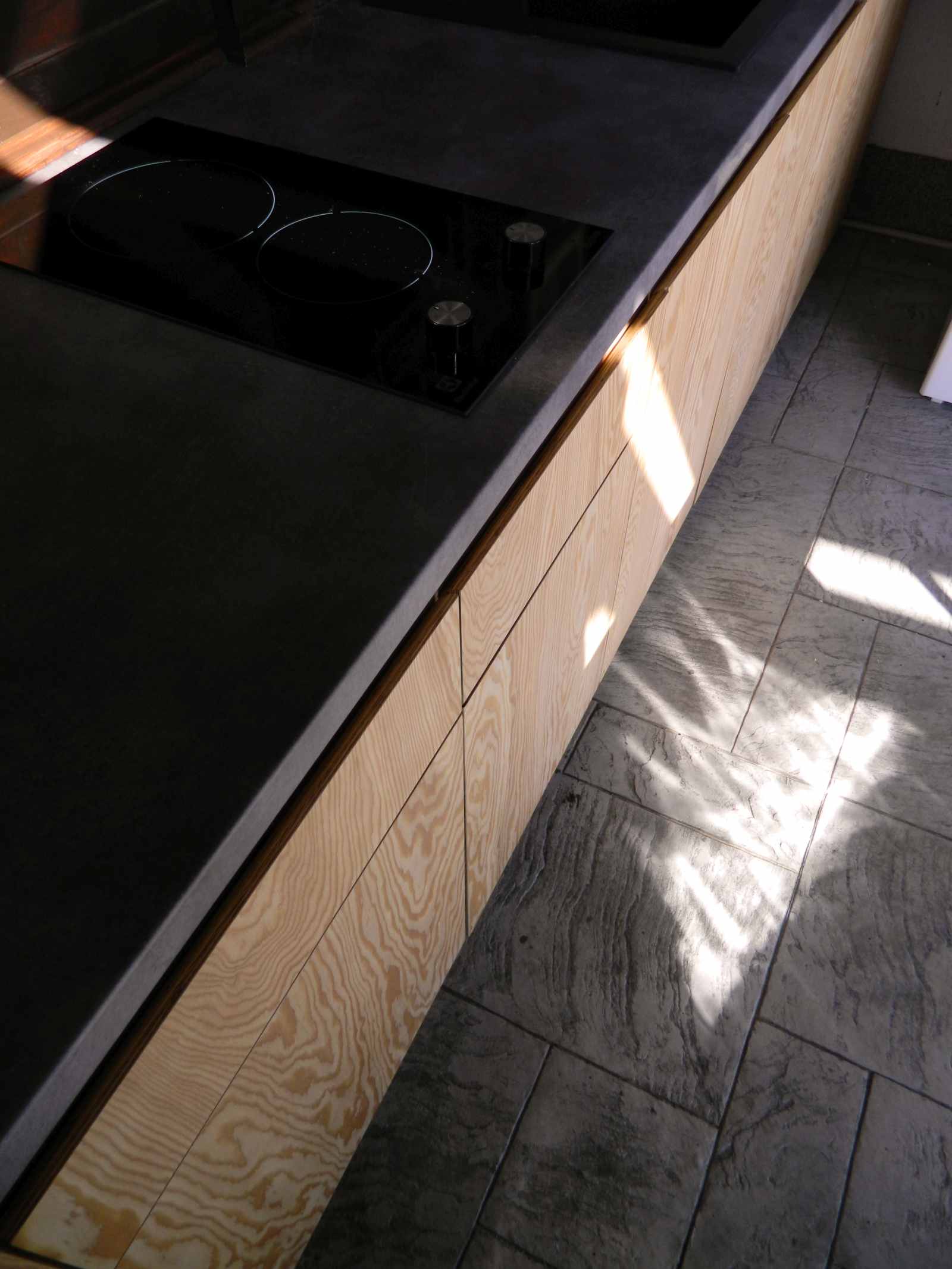 Vedere de sus cu corpuri de bucatarie joase si blat gri melaminat, in lumina naturala difuza