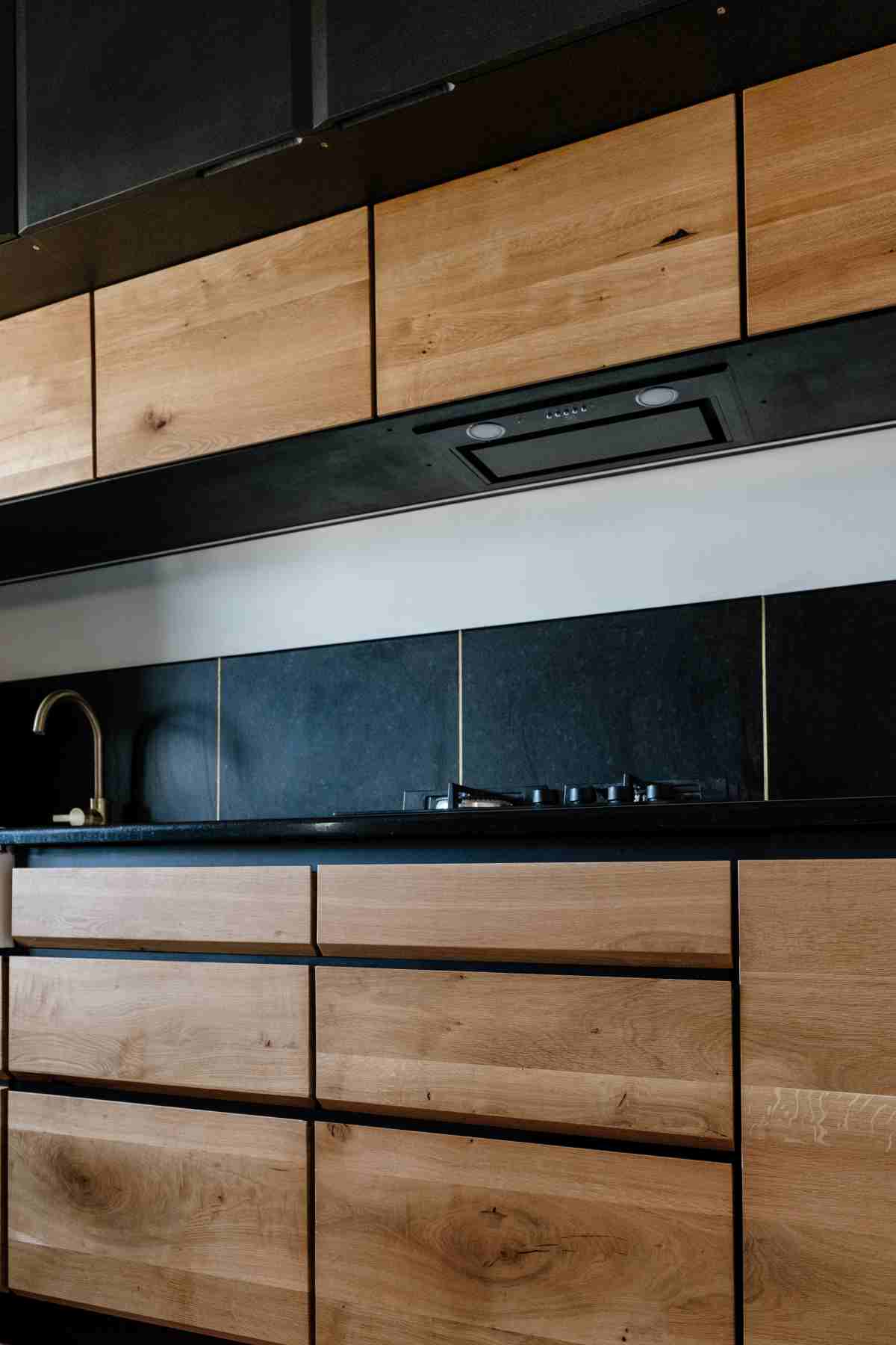 Corp inferior cu sertare din lemn de stejar cu muchie tesita. Pe blat este plita iar in corpul suspendat este vizibila hota incorporata.