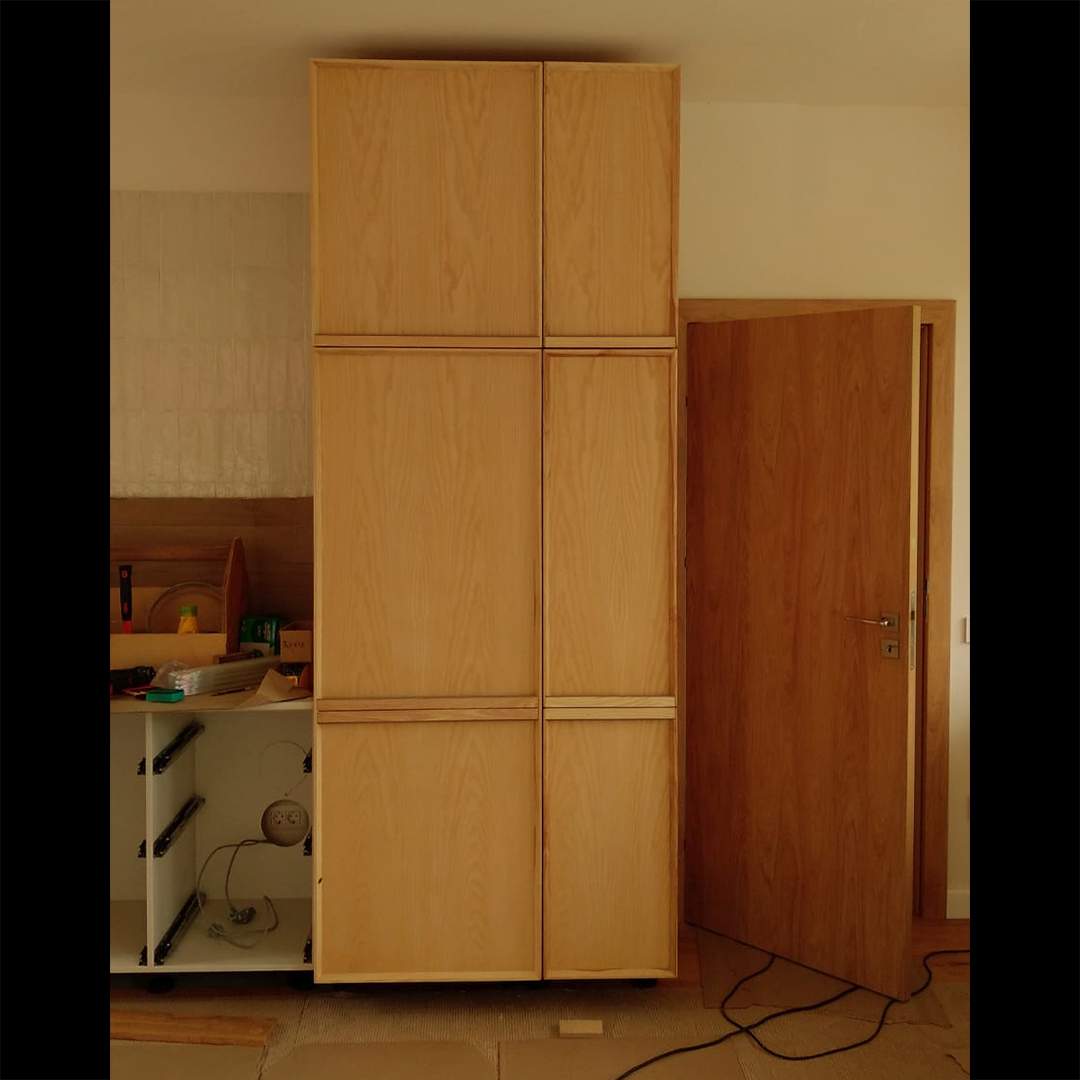 faza de montaj a bucatariei cu dulapuri deschise langa dulapul inalt cu usi cu rame profilate din lemn