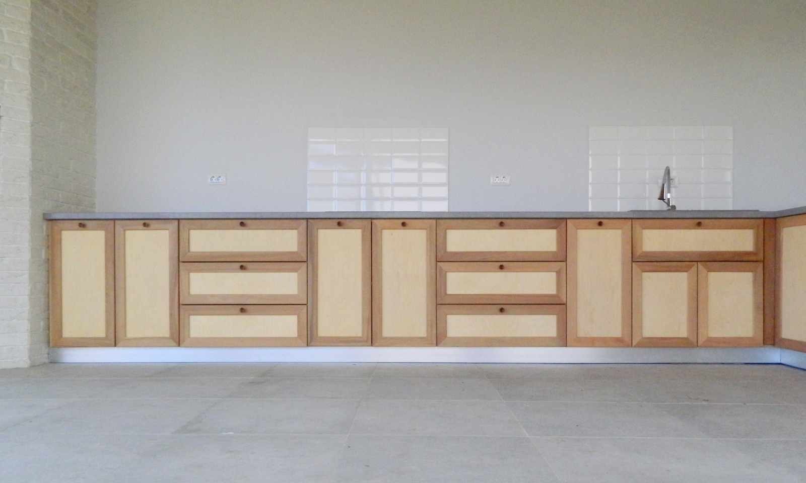 vedere frontala cu intreaga bucatarie cu usi si sertare cu rame din lemn masiv cu imbinari traditionale si tablie din placaj deschis la culoare